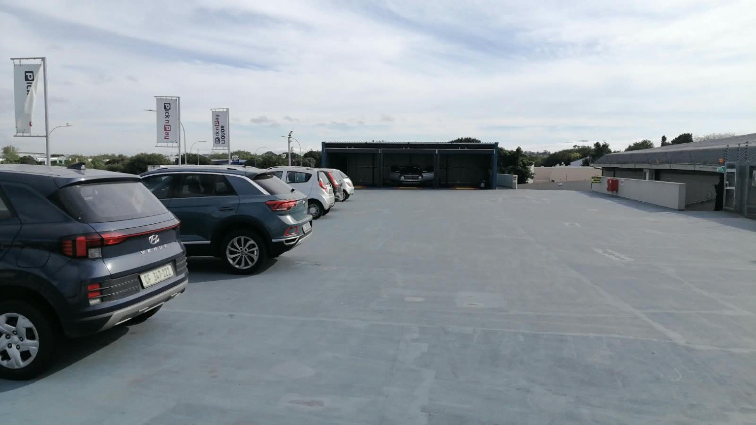 Wide view across the rooftop parking towards the wash bays