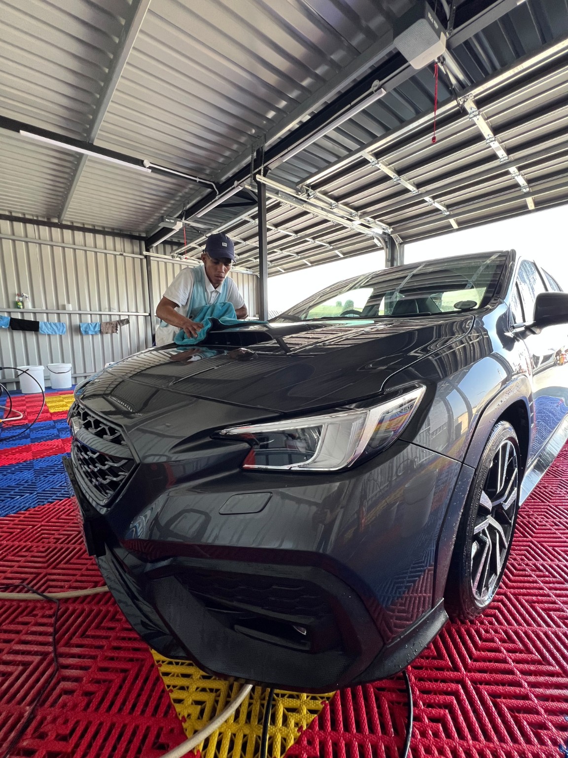A Kwikky team member carefully cleaning a vehicle